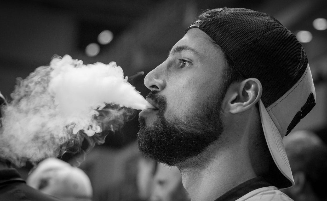 jeune homme qui fume une vape