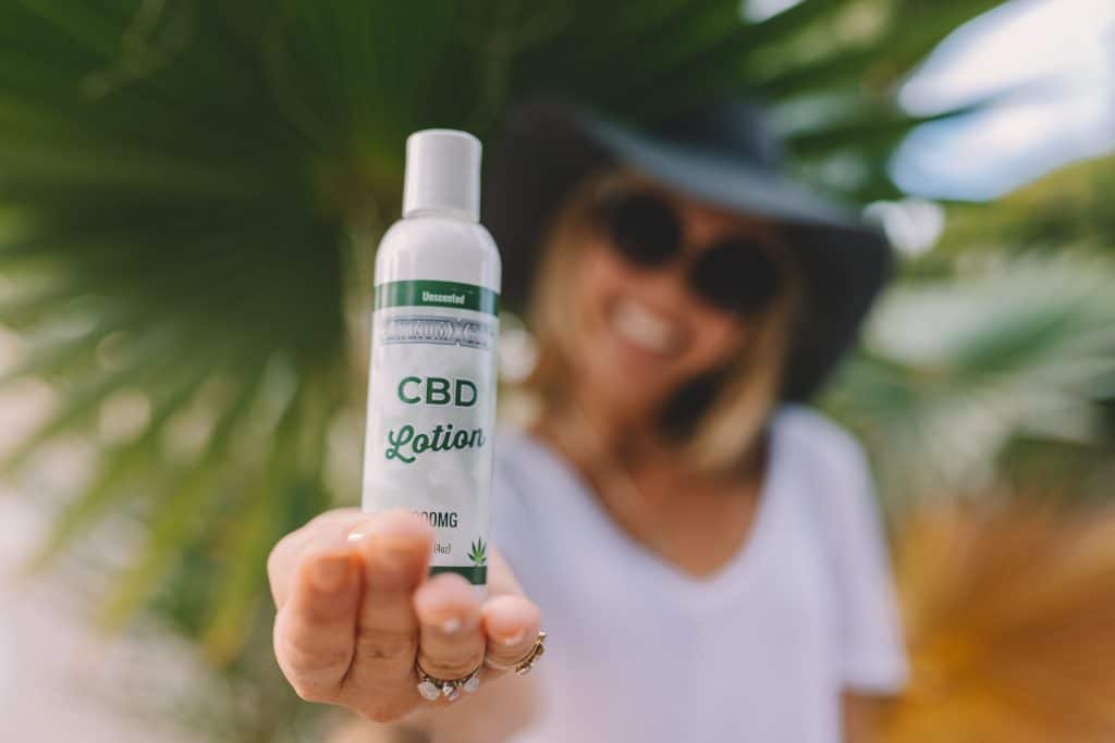 Une femme montrant une lotion à base de CBD