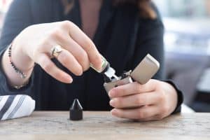 Une femme rechargeant sa cigarette électronique en e-liquide