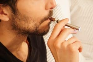 Un homme fumant une cigarette électronique